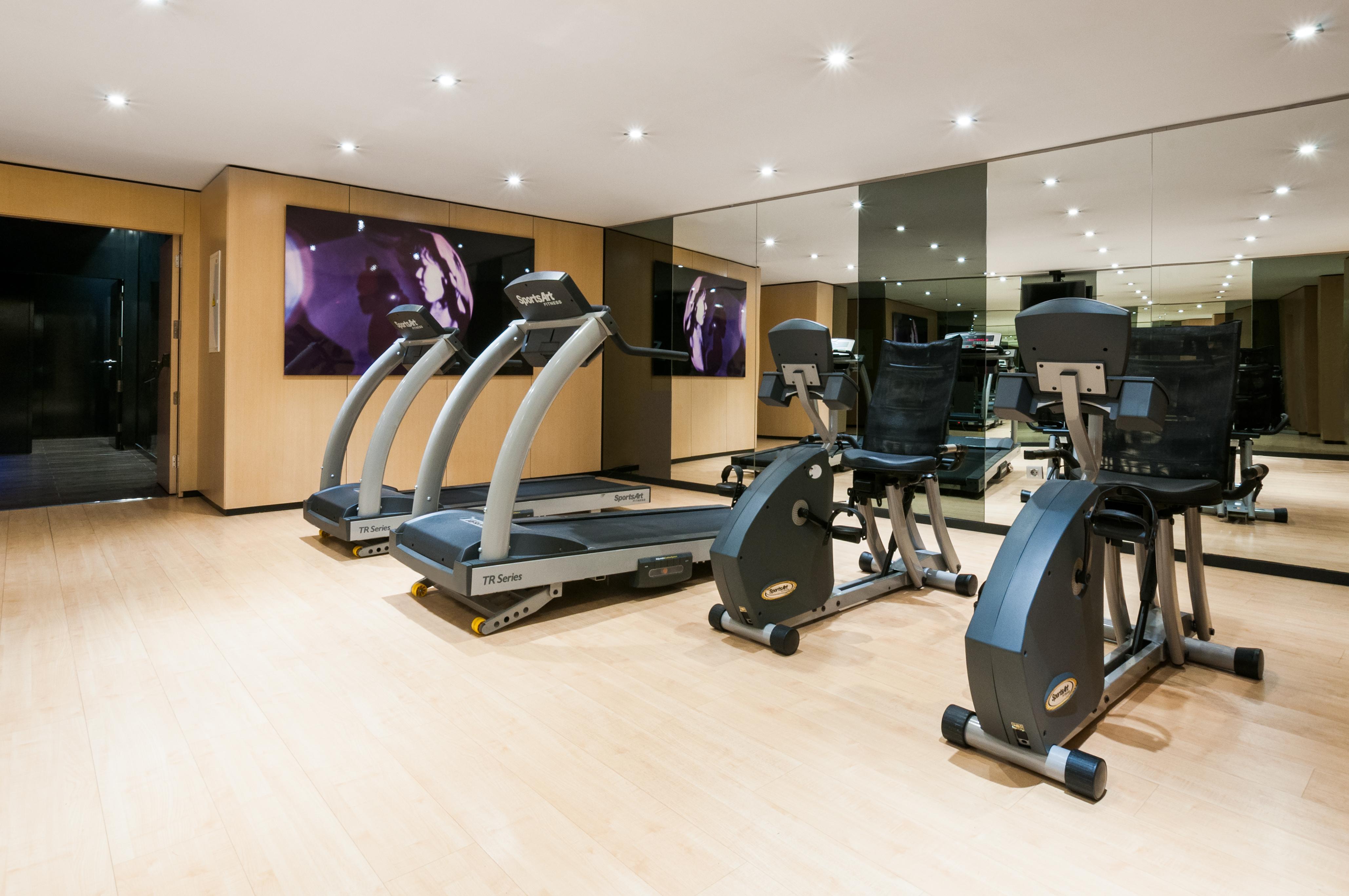 فندق يوروستارز بالاس قرطبة المظهر الخارجي الصورة The photo shows a modern gym or fitness area. It features several pieces of exercise equipment, including treadmills and stationary bikes. The room has bright lighting and a wooden floor, contributing to a clean and open atmosphere. There is a large 