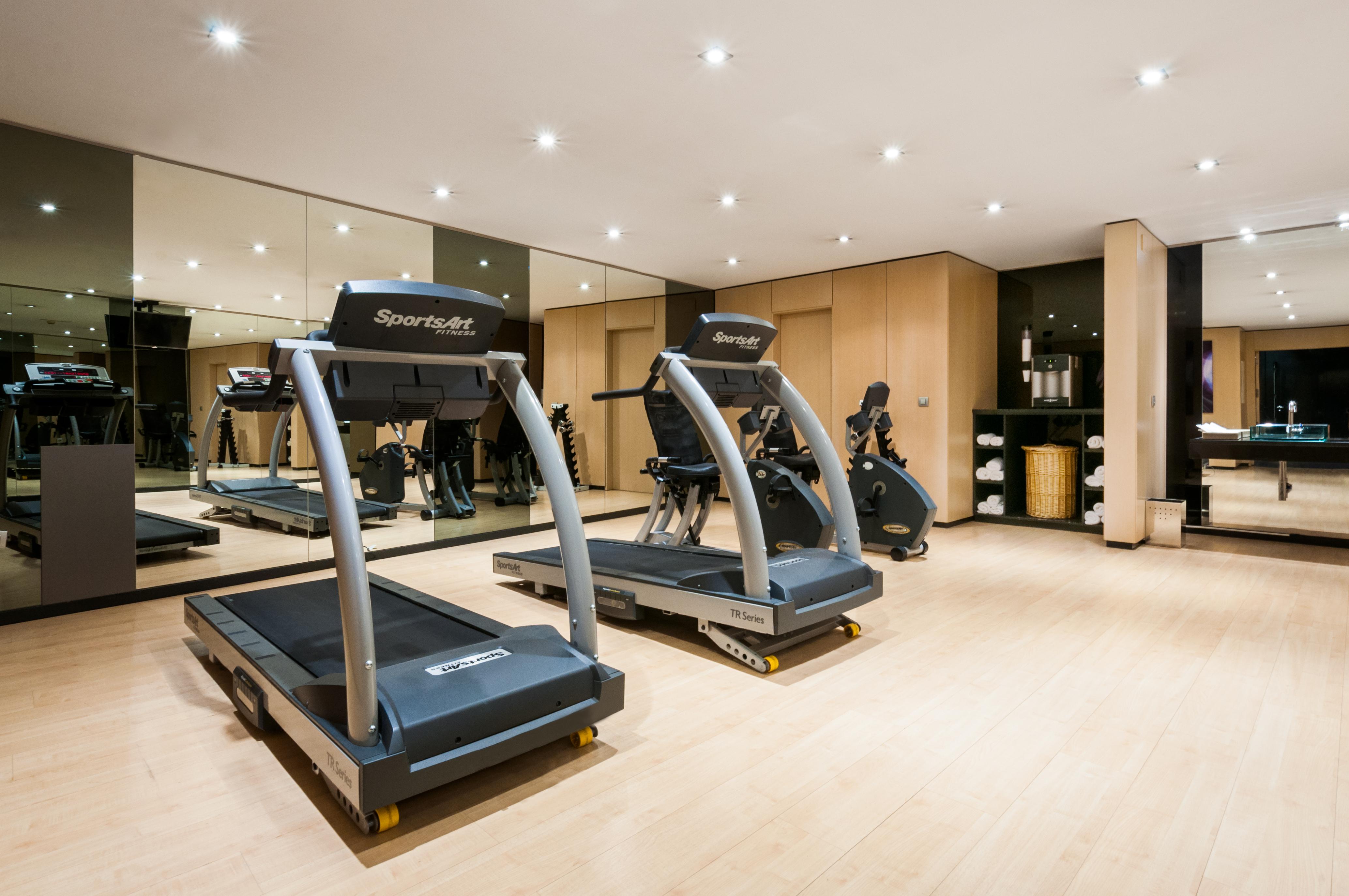 فندق يوروستارز بالاس قرطبة المظهر الخارجي الصورة The photo shows a modern gym or fitness area featuring two treadmills. The equipment is well-maintained and positioned on a light wooden floor. There are mirrors on the wall reflecting the workout area, which adds to the spacious feel. The overall se